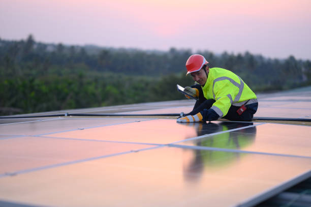 istock Male engineer inspecting solar panels on the roof Engineer or worker working on solar panels or photovoltaic cells on the roof of a business building. 1940020900