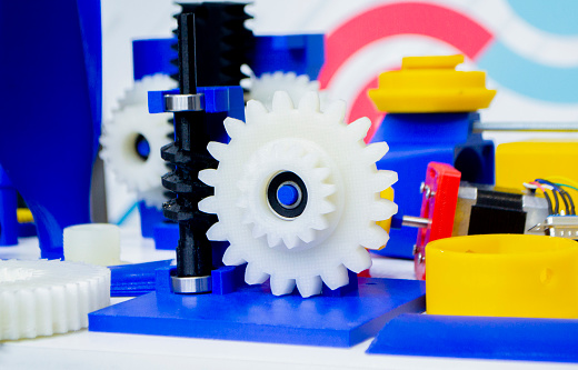 Objects printed on 3D printer from plastic close-up. New 3D printing technology. Concept modern new progressive additive technology. 3D models red yellow white blue created by additive 3d printing