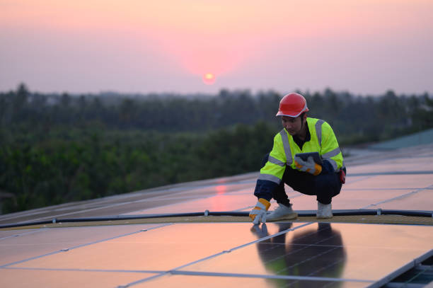 istock Male engineer inspecting solar panels on the roof Engineer or worker working on solar panels or photovoltaic cells on the roof of a business building. 1940043450