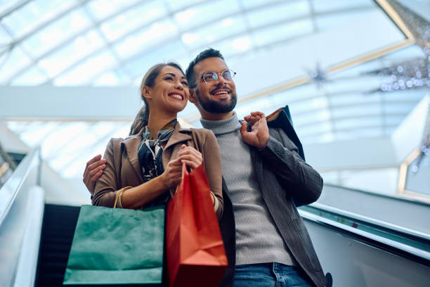 istock Yong happy couple on escalator in shopping mall. 1940047111