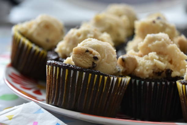 istock Cookie Dough Cupcakes, One Cupcake on Edge of Plate in Center-Left Focus 1940049755