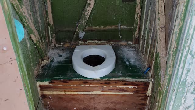 Hole of an old dirty country toilet, rural toilet inside