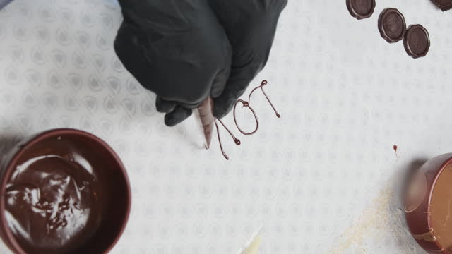Chef writes romantic inscription using piping bag with chocolate