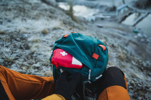 istock First aid kit sticks out of backpack pocket, camping equipment for survival in the forest, pack backpack for travel. 1940092146