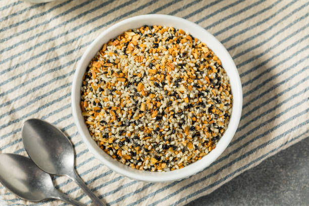 organic dry everything bagel seasoning spice - sesame seed spoon variation foto e immagini stock