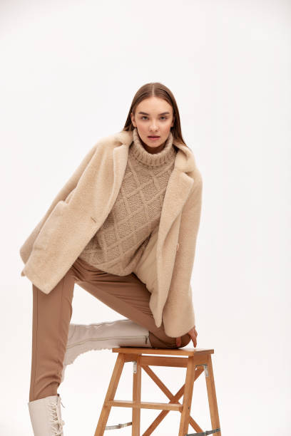 istock Model in a fur coat with artificial fur close-up, light background 1940092708