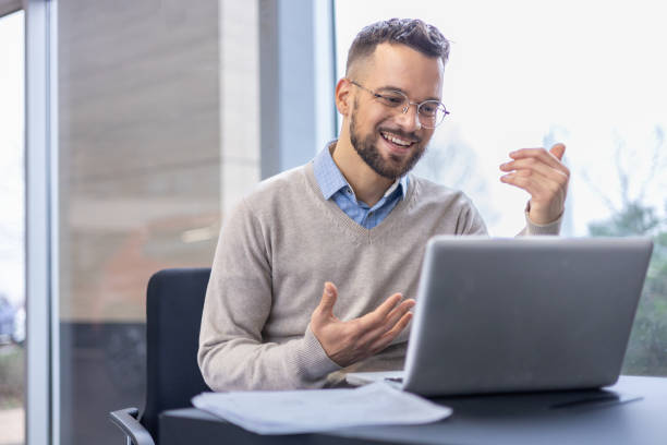 homem que trabalha em computador portátil em um ambiente de escritório - multi tasking efficiency financial advisor business - fotografias e filmes do acervo