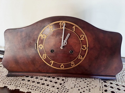 Antique wooden clock, on a handmade crochet tablecloth without wooden furniture.