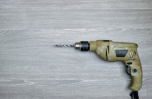 electronic screwdriver drill hand tool on wood table. DIY industry construction hobby concept