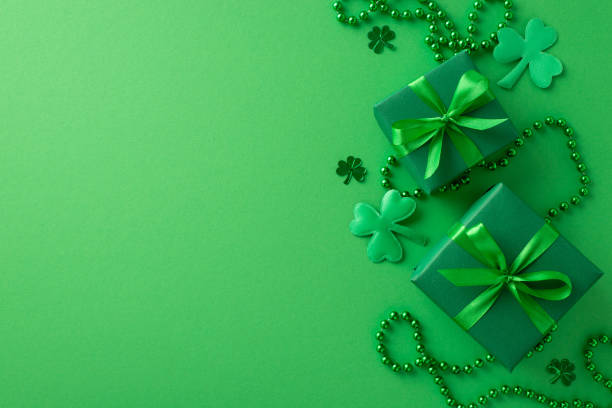 istock Irish festivity snapshot: Overhead composition featuring trendy gift boxes, shamrocks, confetti, beads on a vivid green background. Advertise with style 1940151696