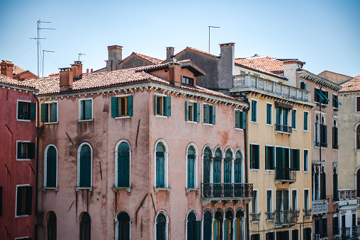 Venice, Veneto - Italy - 06-10-2021: Gondolas docked by vibrant Venetian buildings on a sunny day