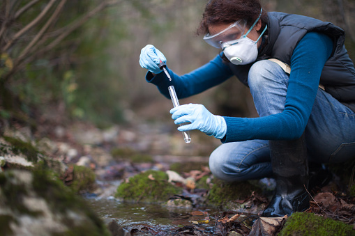 Determinate Biologist Adult Woman On Field Test of Water Stream to Reagents