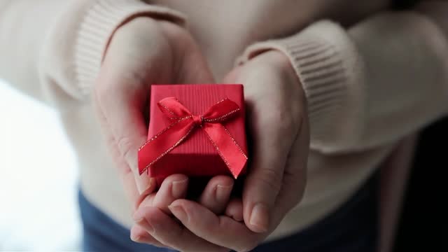 Woman hands holding small red gift box Valentines day anniversary birthday gift