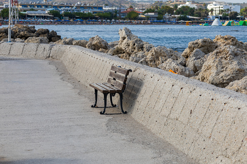 A wooden bench for resting on the pier by the sea.