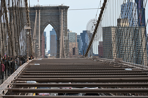 New York City, New York, USA, April 8, 2023 - Tourists and locals walk across the Brooklyn Bridge, with the Manhattan skyline in the background.