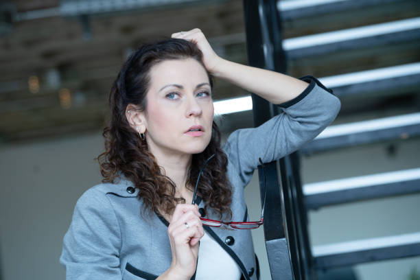 istock Thoughtful, pensive office woman holding her glasses while absorbed in thoughts 1940231627