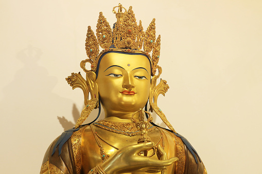 Bronze sculpture of Buddha wearing a crown.