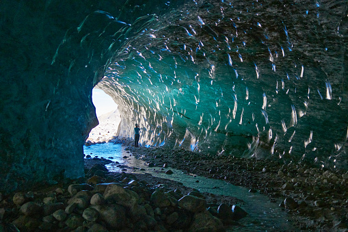 Two hikers contemplate the interior of an ice cave located under the Universidad glacier (one of the largest in Chile), located in the central area of the country, in the O'Higgins region.