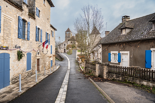 french village street with church and stone house in the background