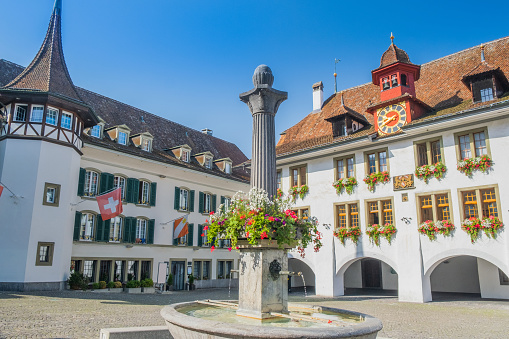 The Arcas, surrounded by rows of historic houses, is one of the beautiful squares in Chur, the capital town of the Swiss canton of Graubunden. People are sitting at the outdoor tables of the cafés.