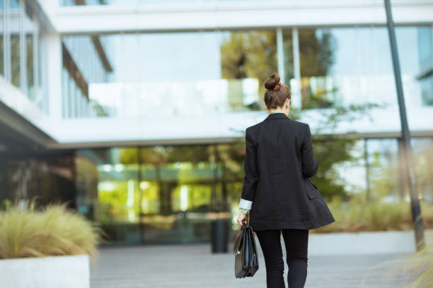 istock Seen from behind woman worker near office building walking 1940361136