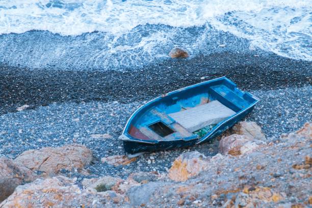 Old traditional fishing boat abandoned on a beach in Almeria, Spain.