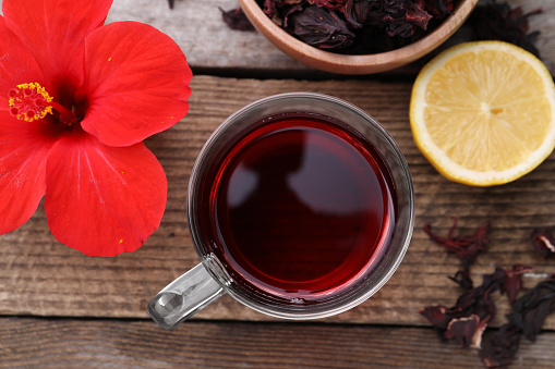 Flat lay composition with delicious hibiscus tea on wooden table