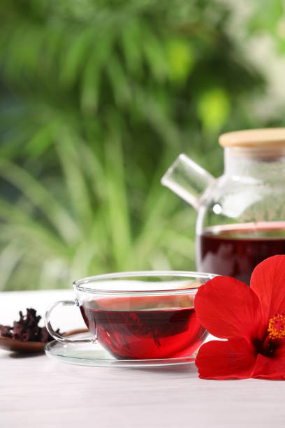 istock Delicious hibiscus tea and flowers on white wooden table outdoors, space for text 1940389662