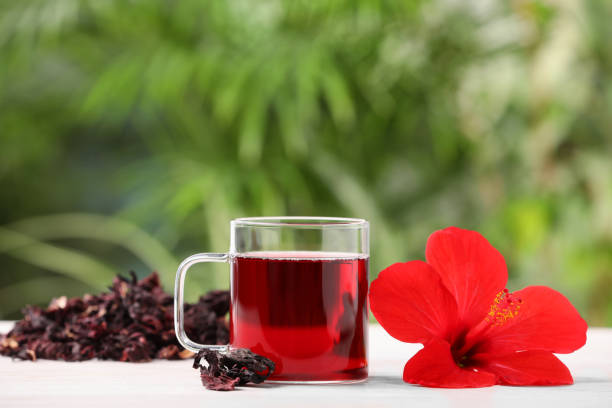 istock Delicious hibiscus tea and flowers on white wooden table outdoors, space for text 1940390181