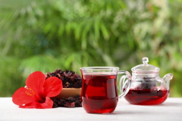 istock Delicious hibiscus tea and flowers on white wooden table outdoors, space for text 1940390194