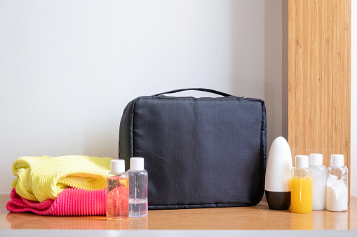 travel cosmetics kit with bottles on hotel room table, front view