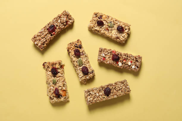 istock Tasty granola bars on yellow background, flat lay 1940398076
