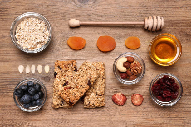 istock Tasty granola bars served on wooden table, flat lay 1940399129
