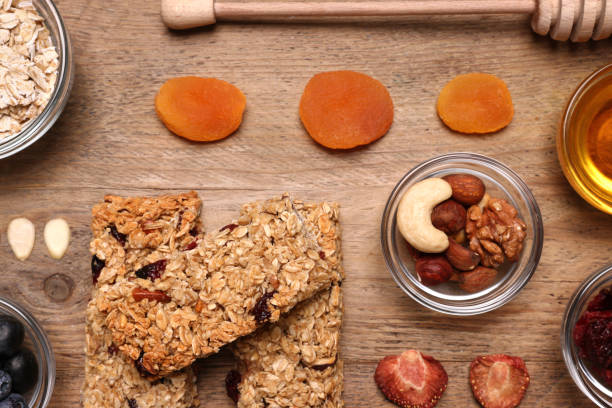 istock Tasty granola bars served on wooden table, flat lay 1940402305