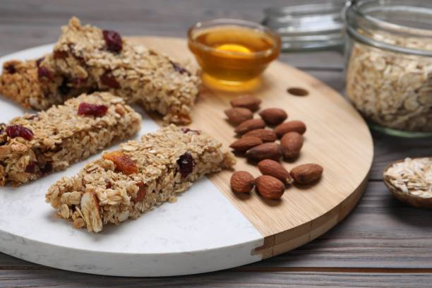 istock Tasty granola bars and ingredients on grey wooden table 1940408683