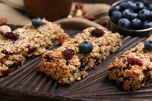 Tasty granola bars with berries on table, closeup