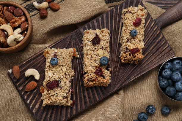 istock Tasty granola bars and ingredients on table, flat lay 1940408697