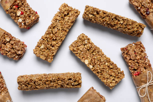 istock Tasty granola bars on white background, flat lay 1940411337