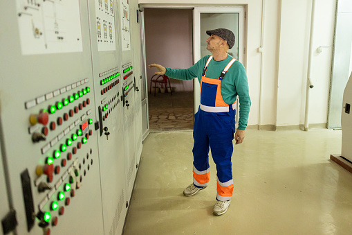 A single worker in protective overalls demonstrates efficiency while using specialized equipment on the factory floor.