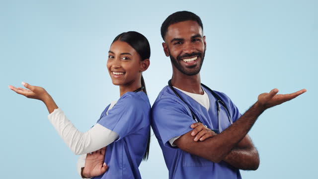Face, teamwork and doctors with show, space and announcement on a blue studio background. Portrait, man and woman with hand gesture for medical professionals, promotion, opportunity with presentation