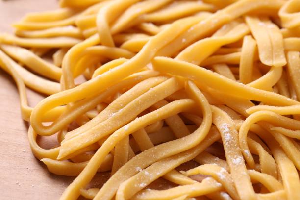 istock Raw homemade pasta on wooden table, closeup 1940434016