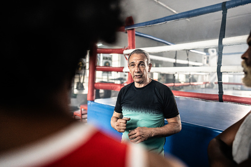 Boxing coach talking boxers on a boxing gym