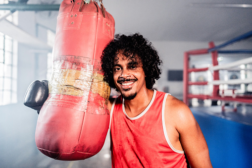 Portrait of a boxer man holding a punching bag on a boxing gym