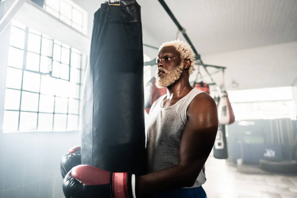 Boxer man holding a punching bag on a boxing gym