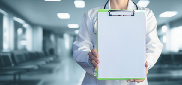 Doctor showing checklist on blurred hospital background.