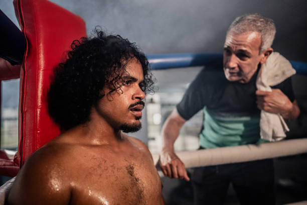 Boxer man receiving instructions by coach on a boxing ring