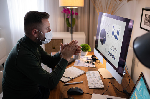 Young business man with face mask an working