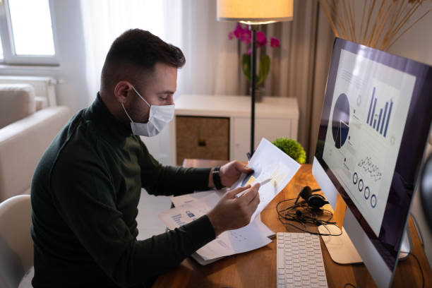 istock Young business man with face mask an working 1940478442