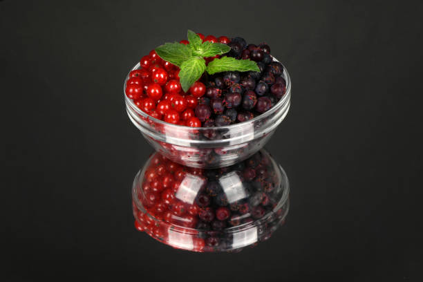 Berries of amelanchier and red currant on glass bowl. High resolution photo. Full depth of field.