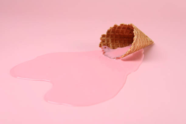 istock Melted ice cream and wafer cone on pink background 1940486356